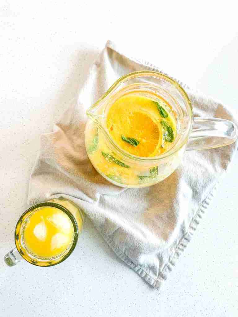 freshly made mint julep punch in a pitcher and a glass