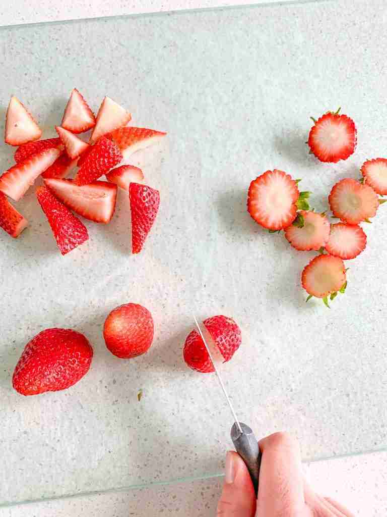 chopping strawberries for Homemade Strawberry Glaze (for Angel Food Cake)