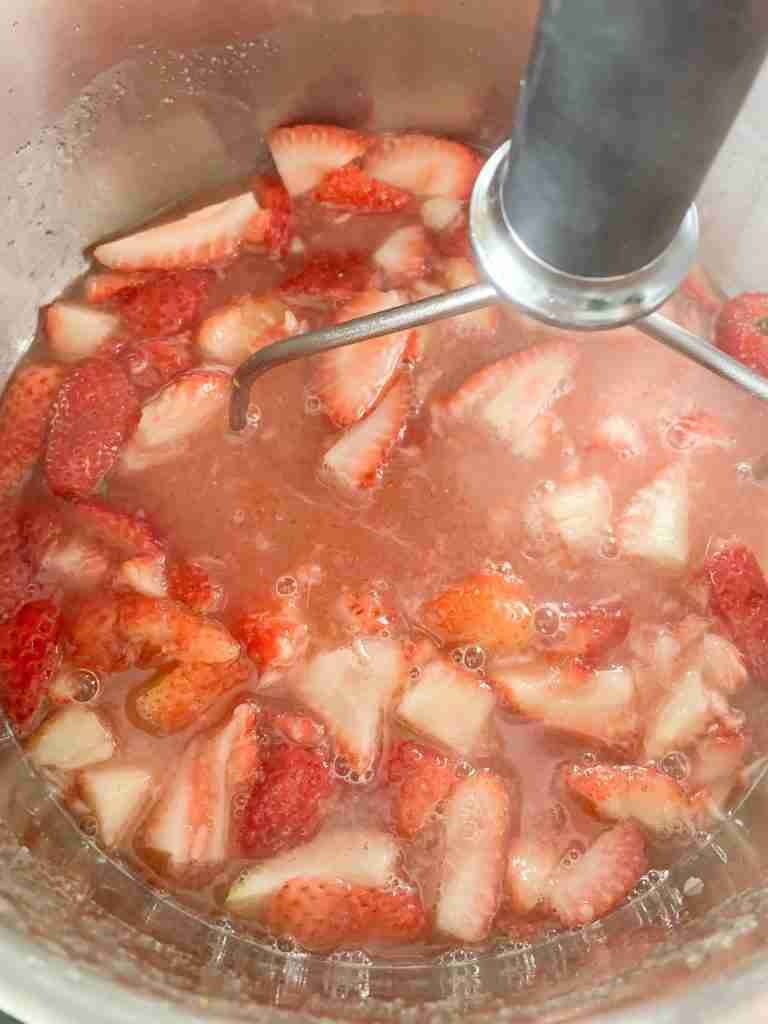 mashing strawberries for Homemade Strawberry Glaze (for Angel Food Cake)
