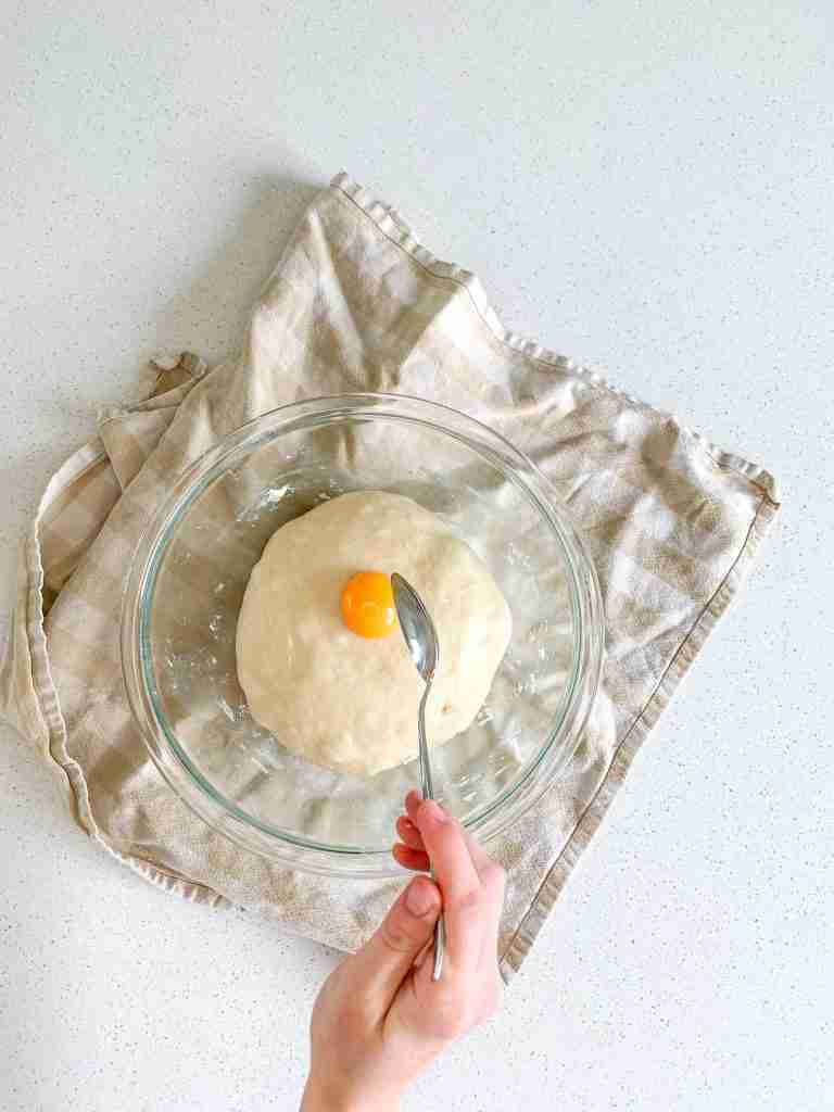adding egg to sourdough brioche bun dough