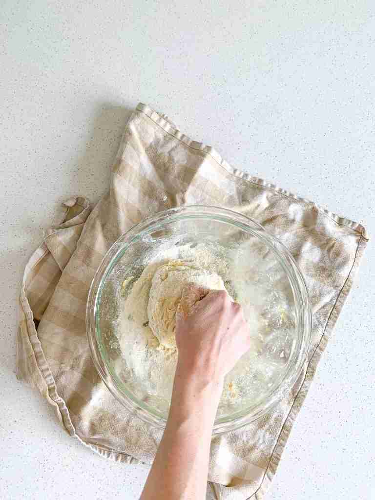 adding flour to enriched sourdough brioche buns dough