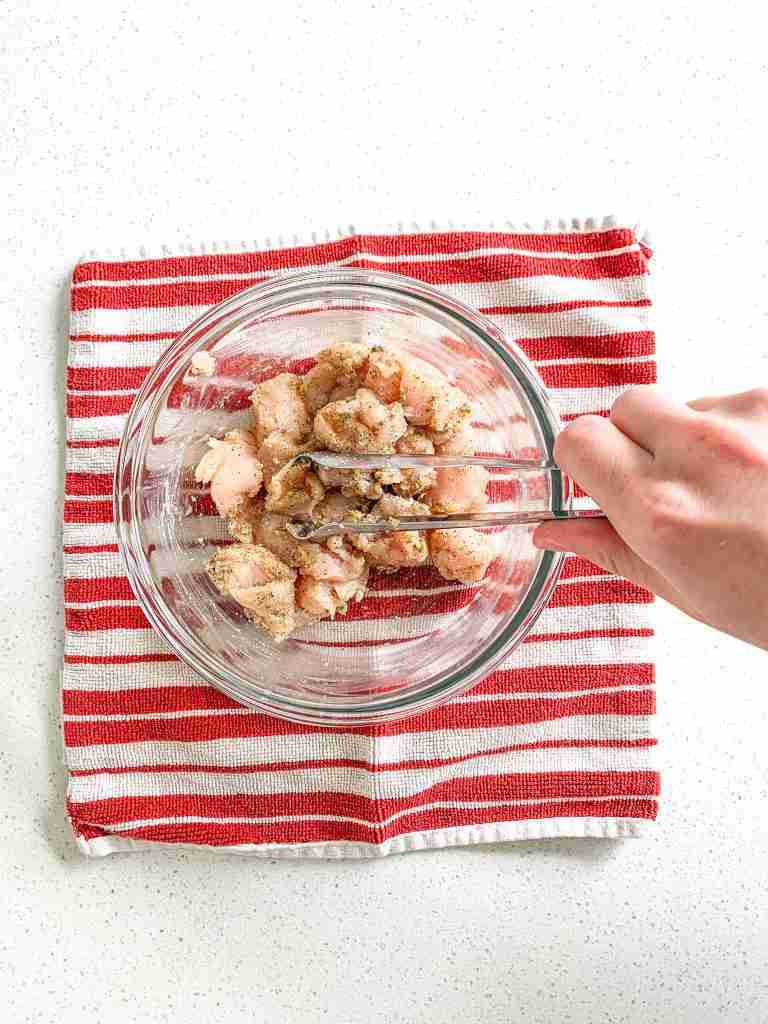 mixing chicken bites in seasoning