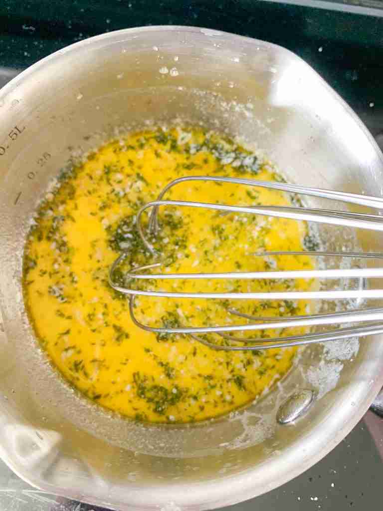 whisking together butter and seasonings for sauce