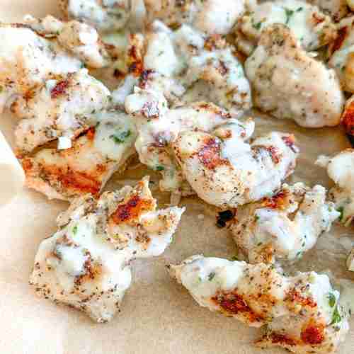 freshly cooked grilled chicken bites with creamy garlic sauce