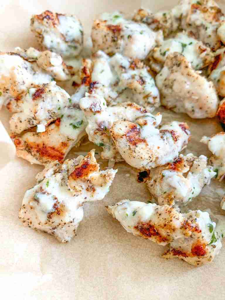 freshly cooked grilled chicken bites with creamy garlic sauce