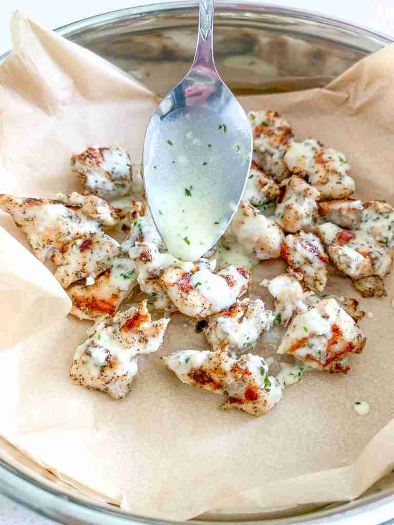 adding sauce to chicken bites