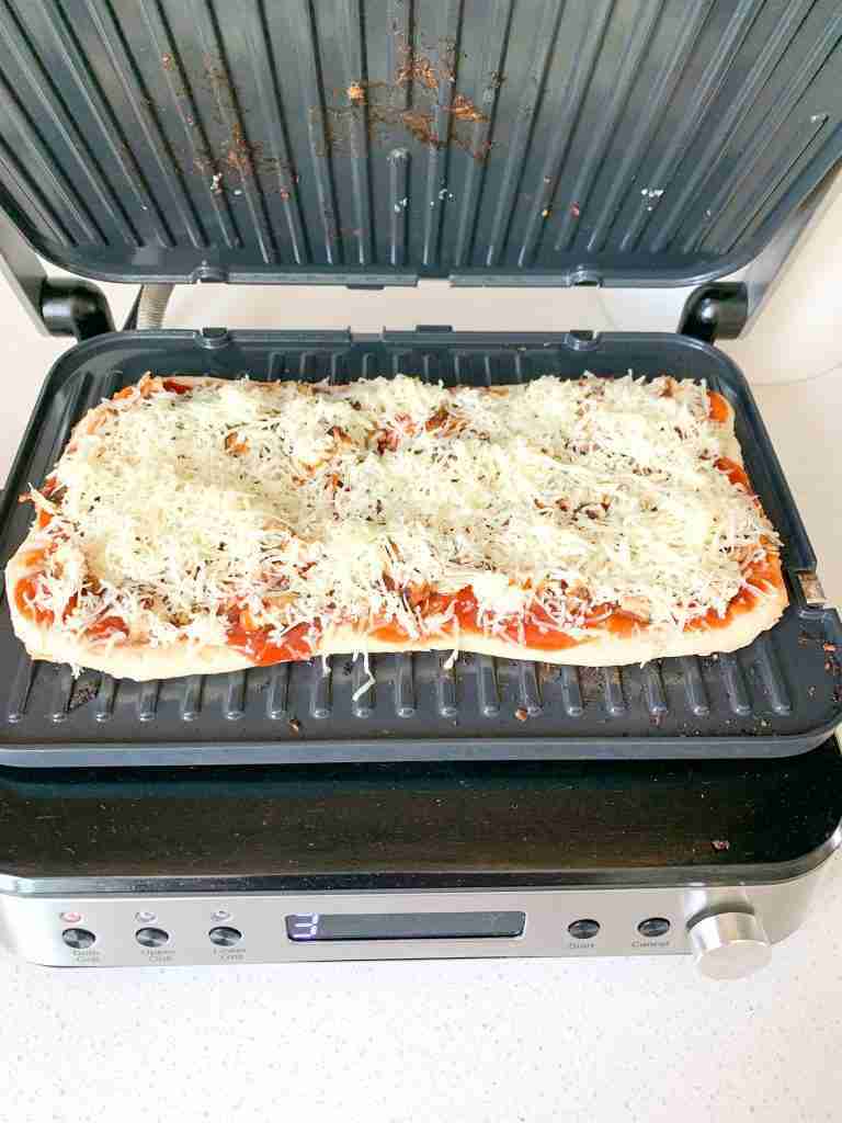 flatbread pizza cooking on a grill