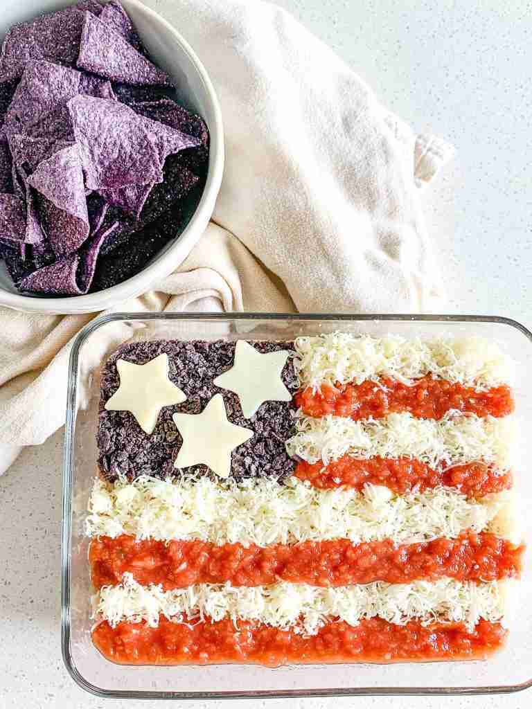 freshly made american flag taco dip with bowl of chips