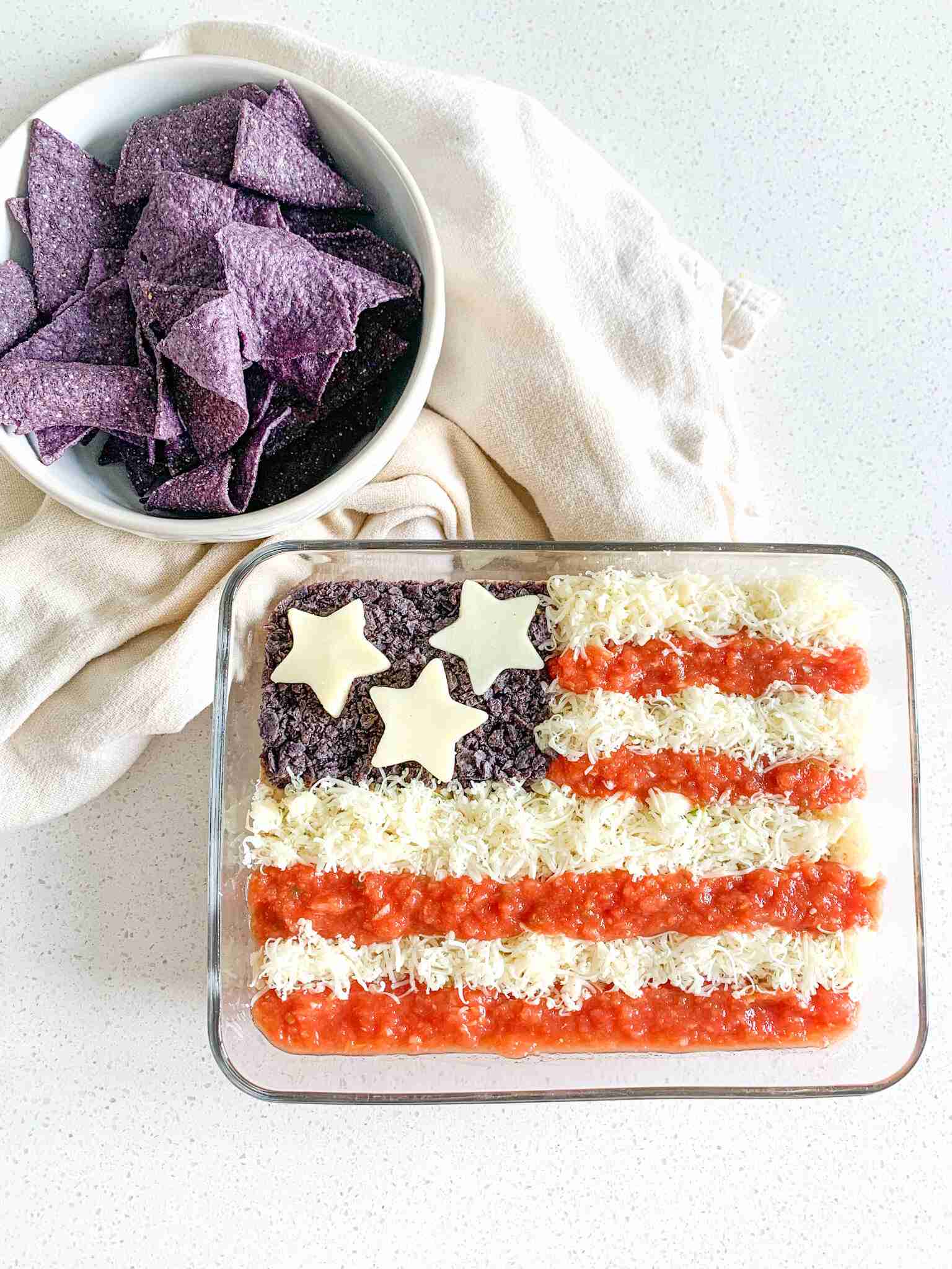 freshly made american flag taco dip with bowl of chips