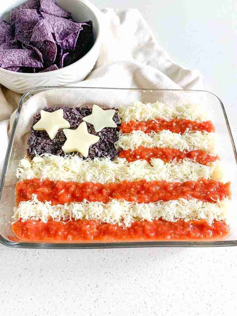 freshly made american flag taco dip with bowl of chips