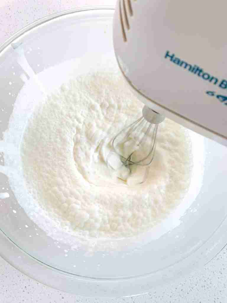 electric mixer whisking cream to make whipped cream