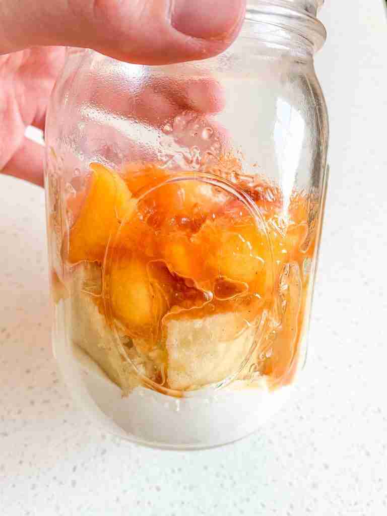 first layers of peach trifle in mason jar