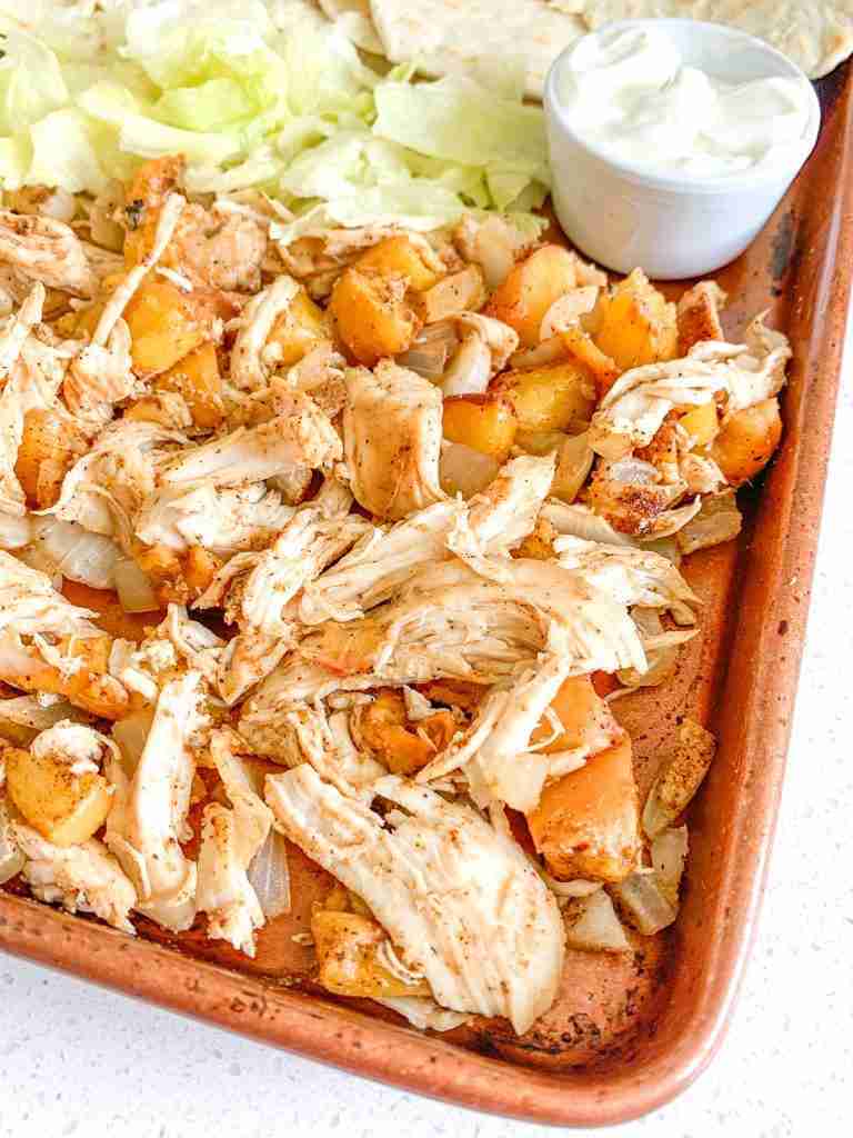 freshly cooked chipotle chicken peach tacos on a sheet pan with tortillas and fixings