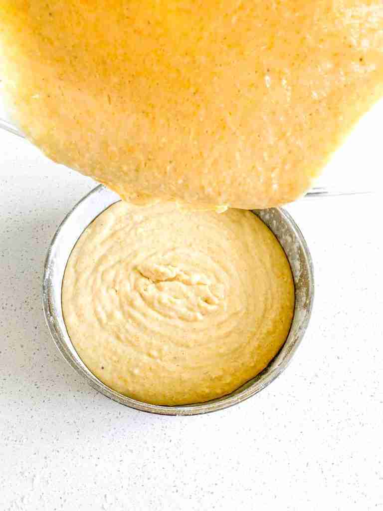 pouring cornbread batter into a prepared pan