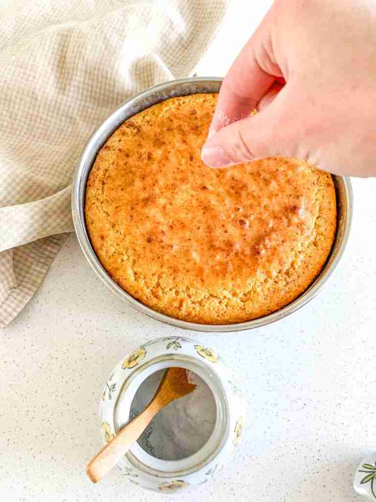 sprinkling sea salt on top of a freshly baked cornbread