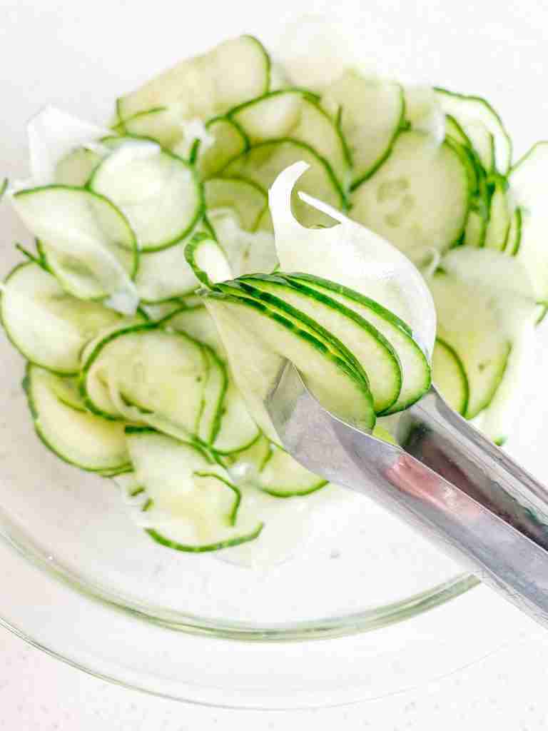 freshly made old fashioned cucumber and onion salad in tongs