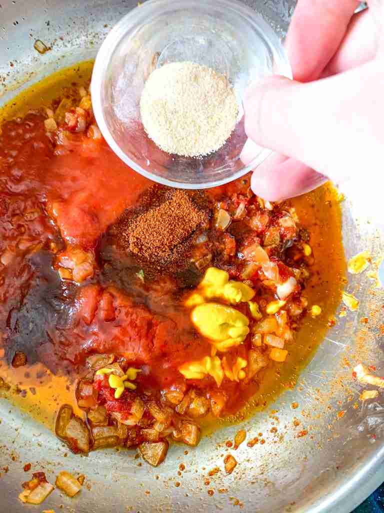 adding spices to a skillet for coney dog sauce