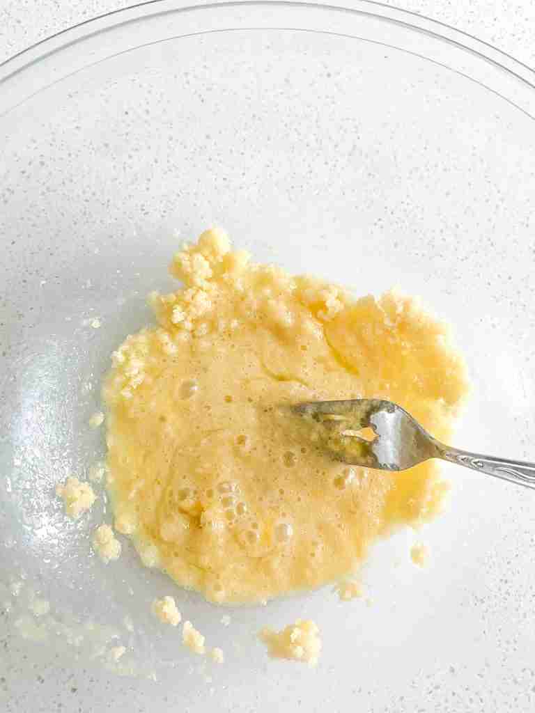 egg getting mixed into butter sugar mix with a fork