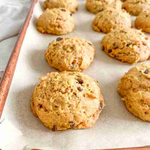 freshly baked mini sourdough chocolate chip pumpkin cookies on a sheet pan