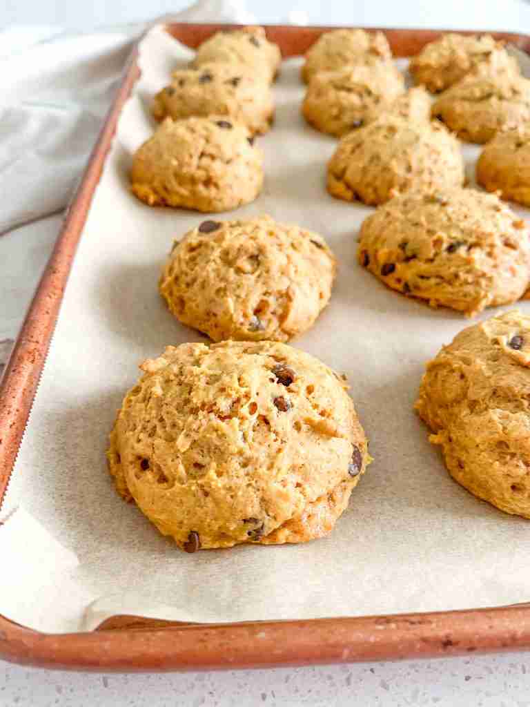 freshly baked mini sourdough chocolate chip pumpkin cookies on a sheet pan