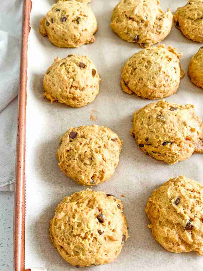 freshly baked mini sourdough chocolate chip pumpkin cookies on a sheet pan
