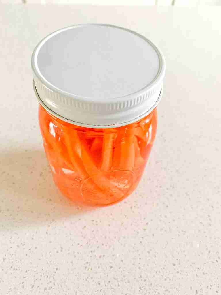 carrots in pickling solution in an airtight jar