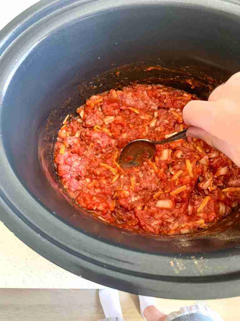 stirring walking taco meat in a slow cooker