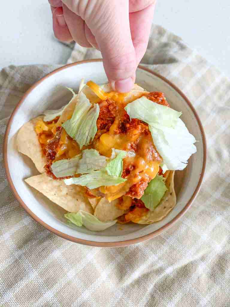 hand picking up a chip of walking taco casserole