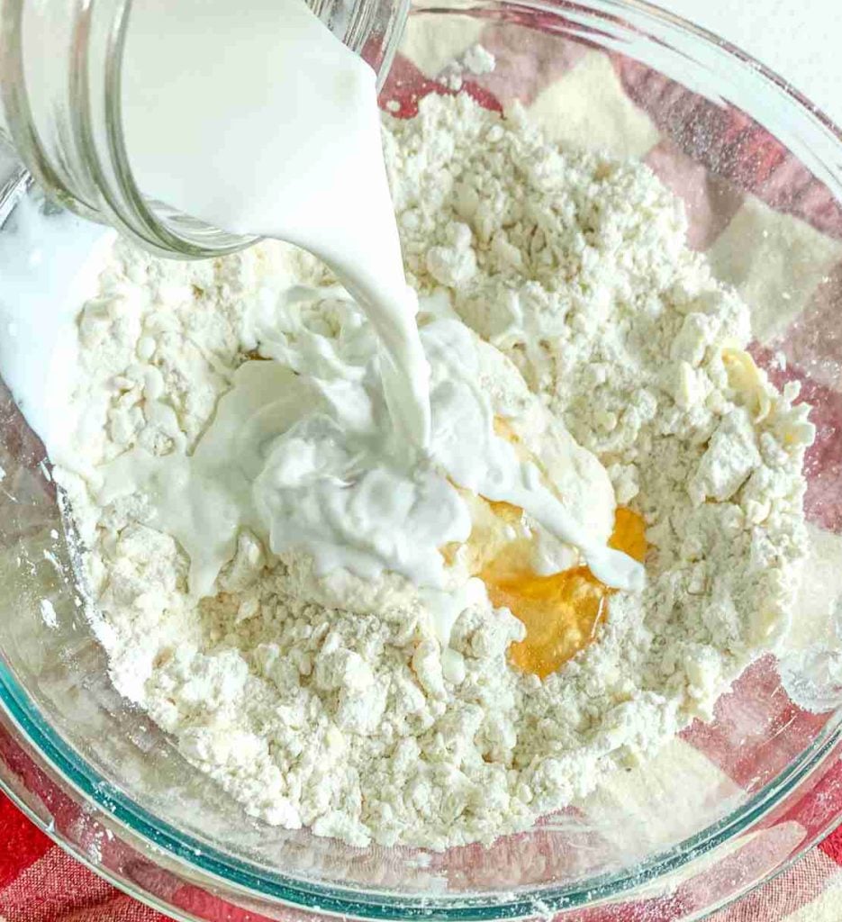 adding wet ingredients to puff pastry dough for turnovers