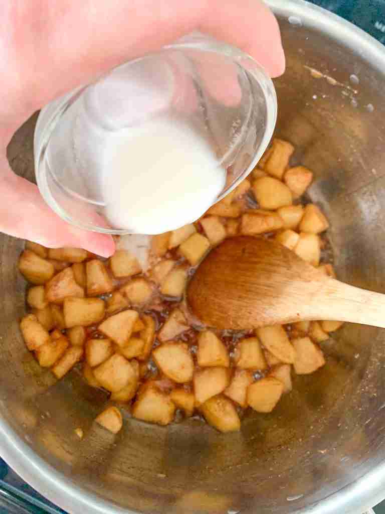 adding cornstarch slurry to apple turnover filling on the stove