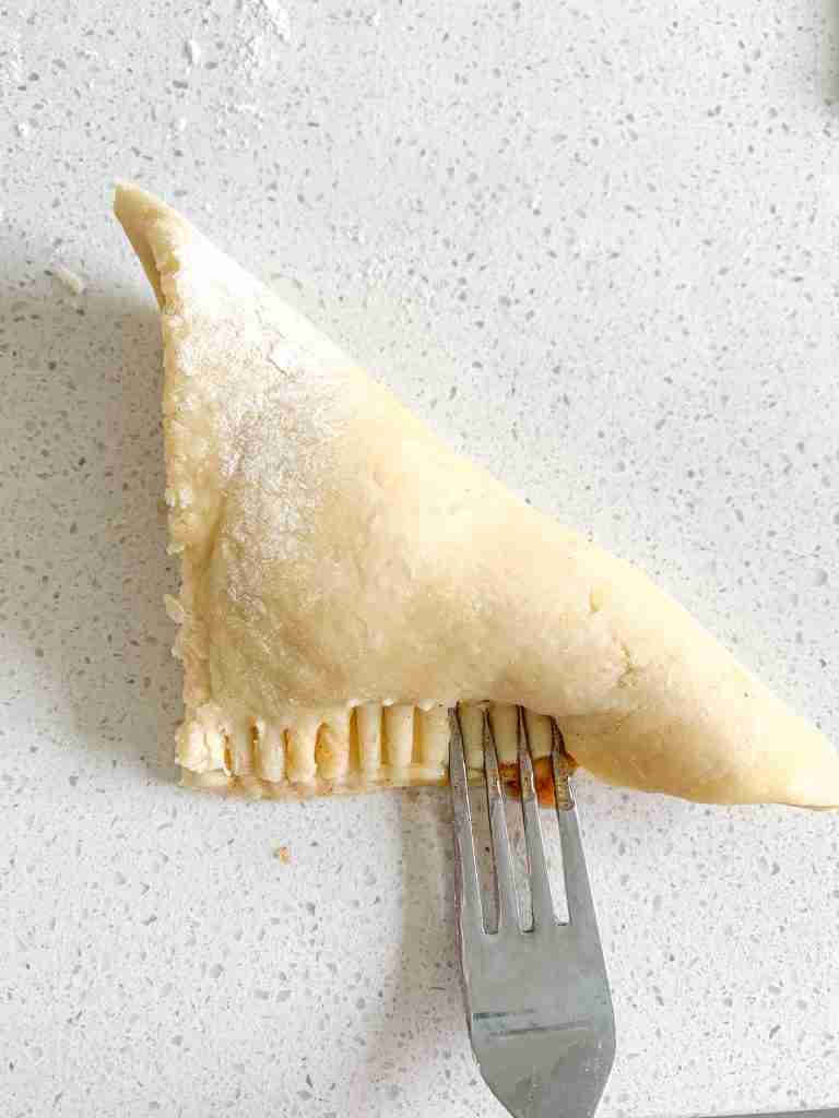 sealing apple turnover dough with a fork