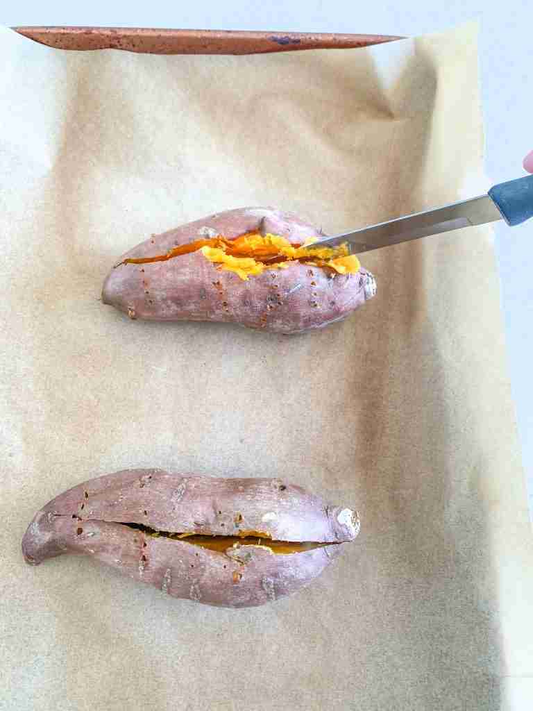 slicing open baked sweet potatoes