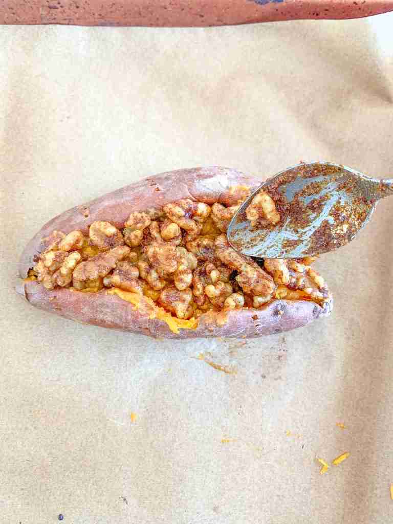filling baked sweet potato with savory walnut topping