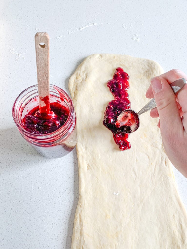 adding cherry filling to rolled our danish dough
