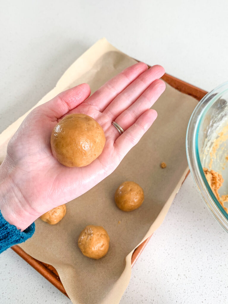 rolling sourdough peanut butter cookie dough in hand
