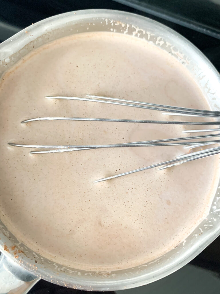 whisking hot chocolate ingredients in a pan
