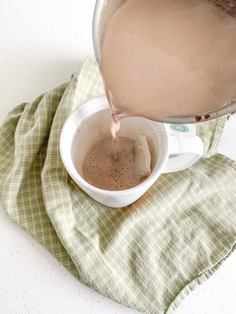 pouring hot chocolate over a tea bag