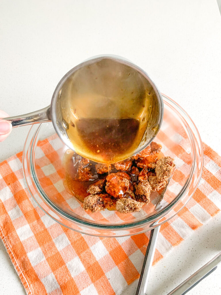 adding orange sauce to baked chicken