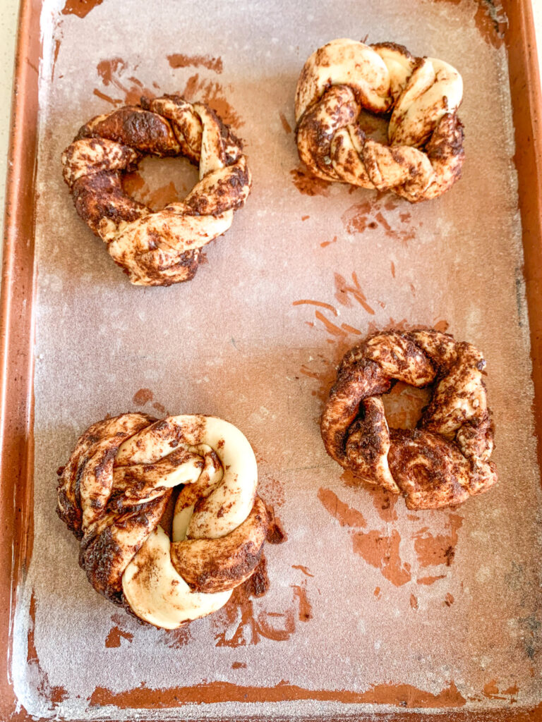 shaped mini king cakes on pan ready to proof