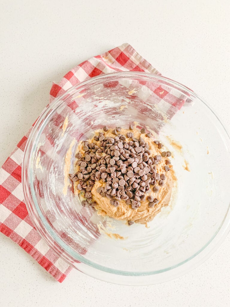 adding chocolate chips to brown butter sourdough cookie dough