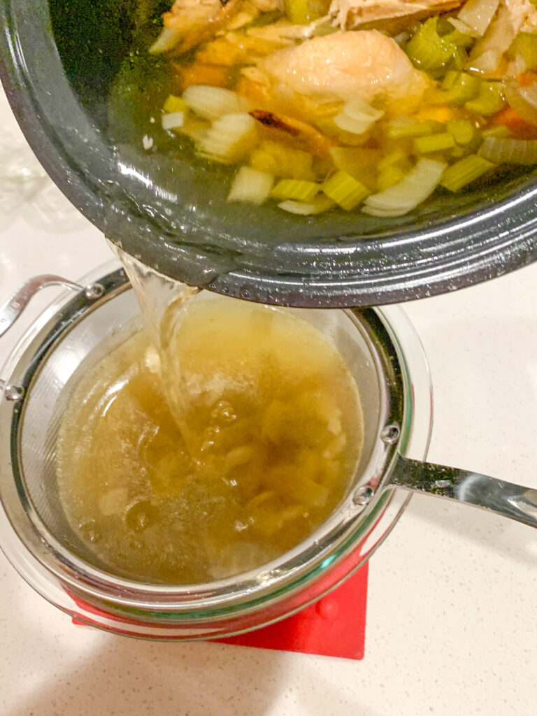 straining chicken stock