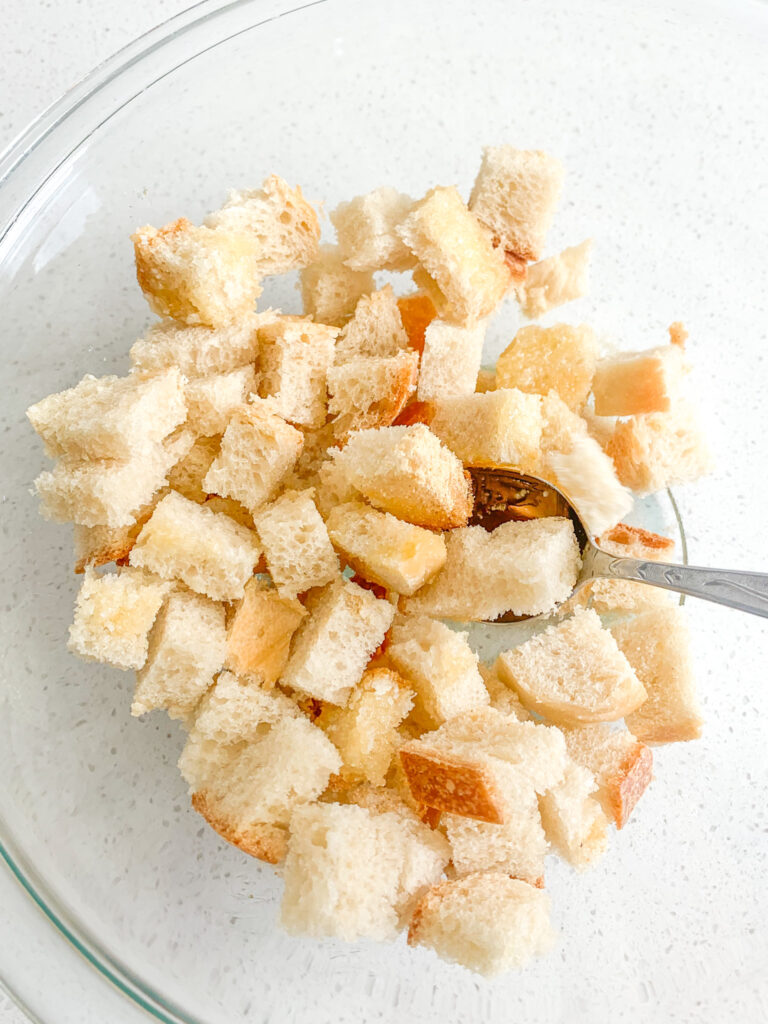 mixing bread cubes with melted butter and spices