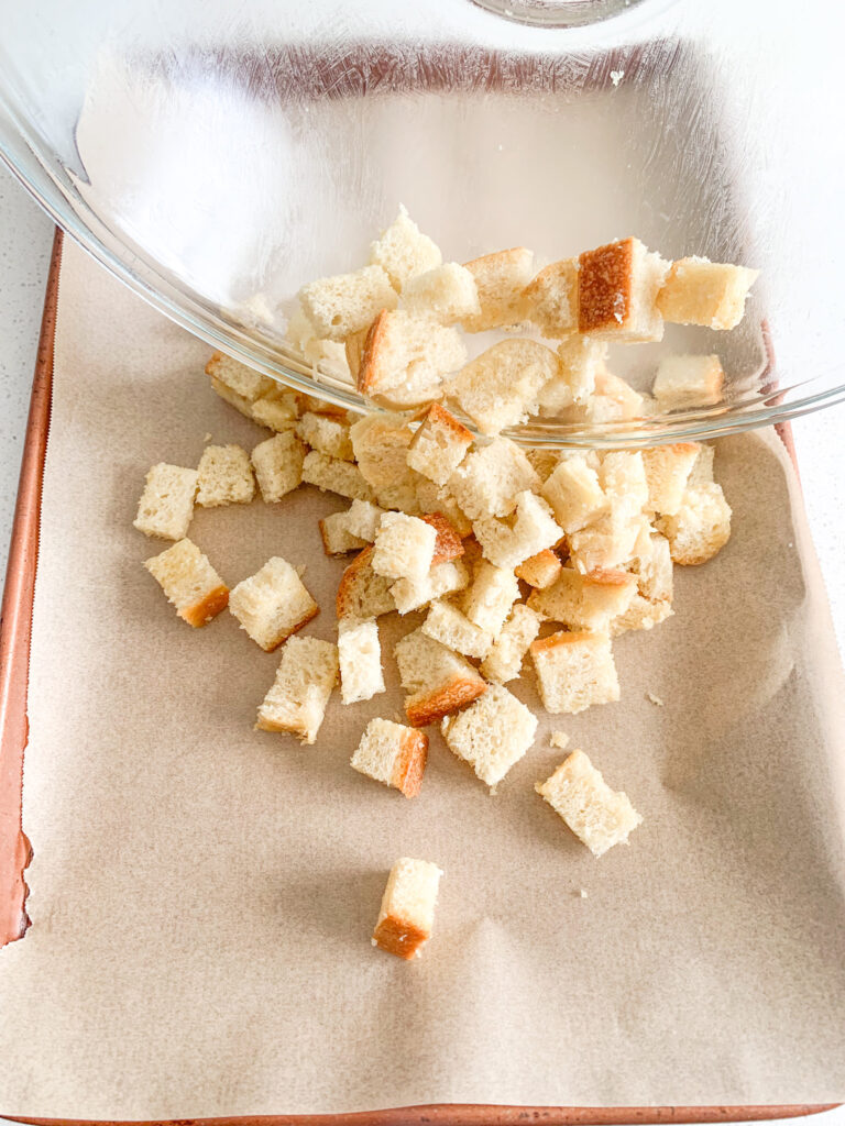 adding croutons mix on a sheet pan for baking
