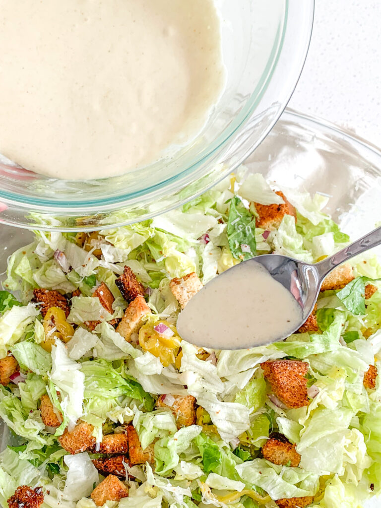 adding dressing to salad bowl