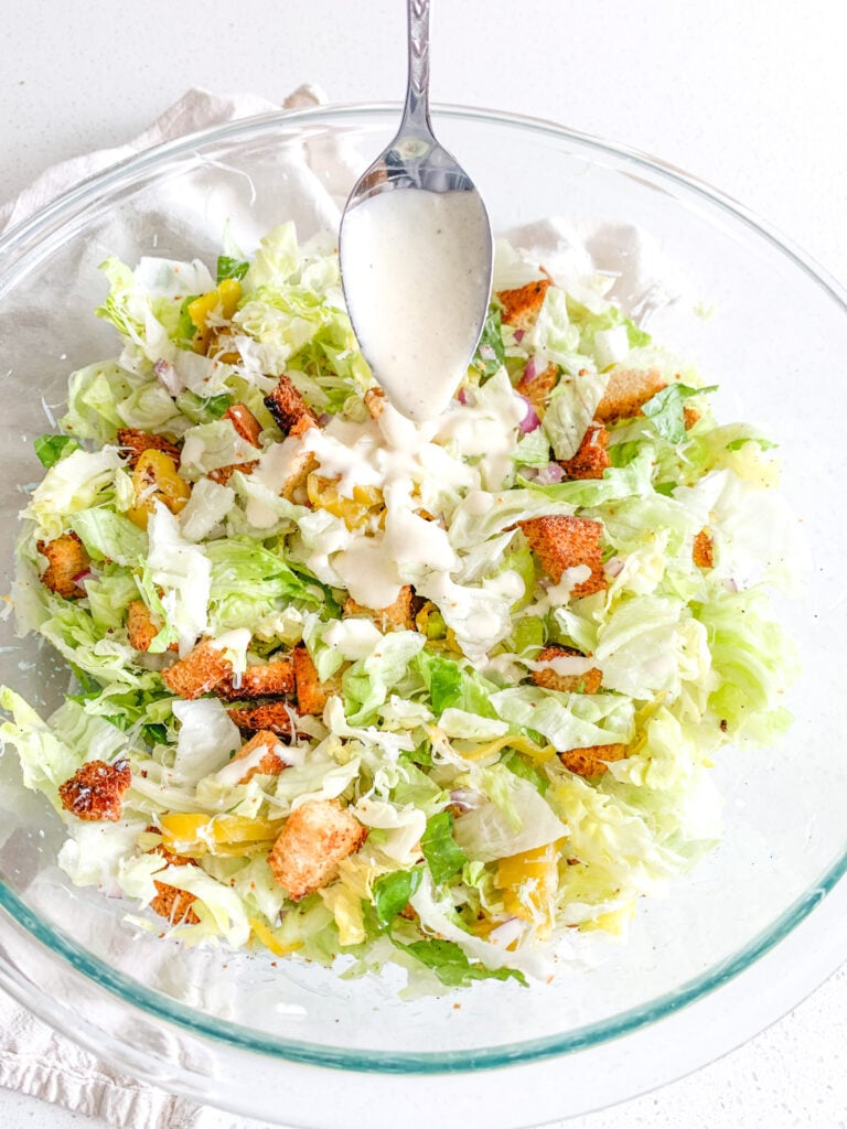 freshly made Italian chopped salad with dressing being added in