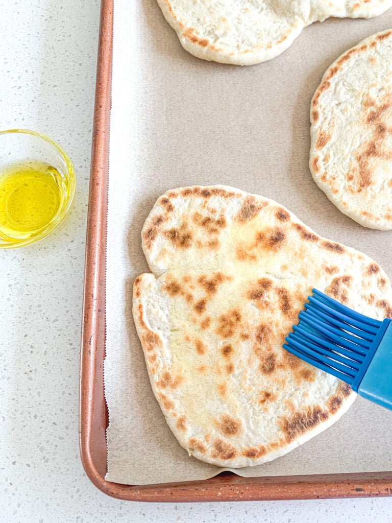 brushing naan bread with olive oil