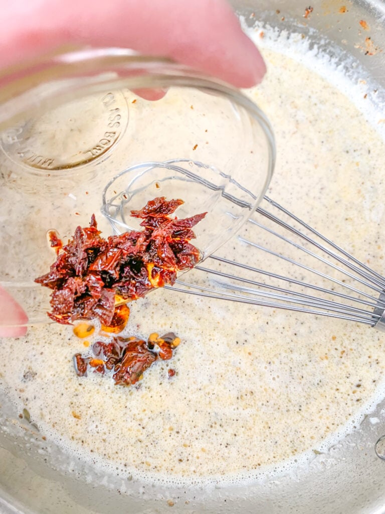 adding sun dried tomatoes to tuscan sauce
