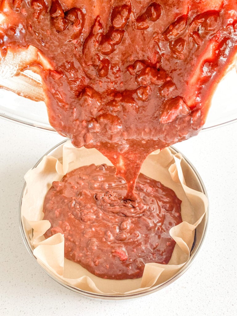 pouring sourdough brownie batter into baking pan
