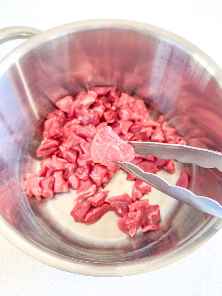 beef stew meat chopped into small pieces into a pot