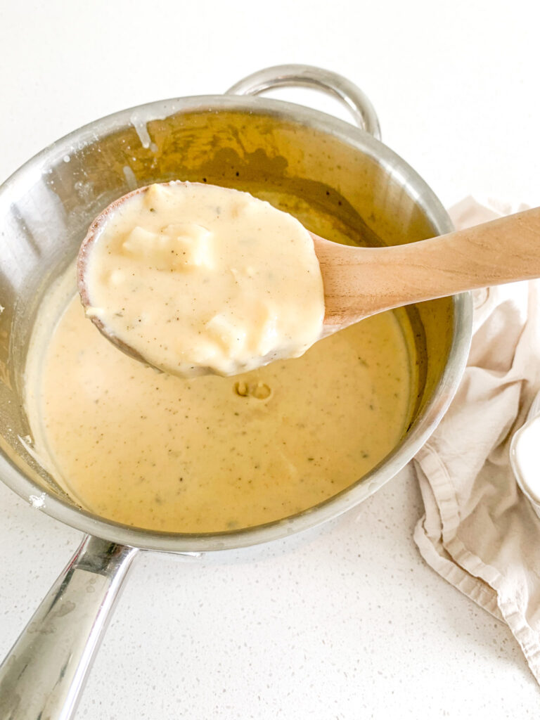 serving freshly cooked potato soup with a ladle